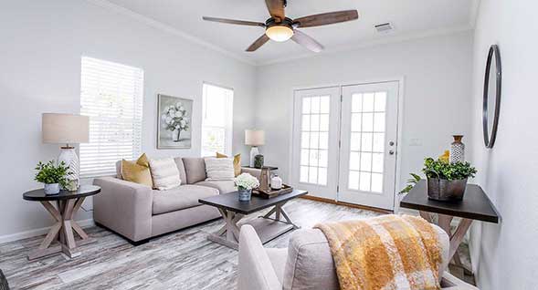 Beautiful, stylish light filled living area with porch and ceiling fan.