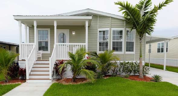 Charm and curb appeal with covered front porch, lush tropical landscaping and bay window