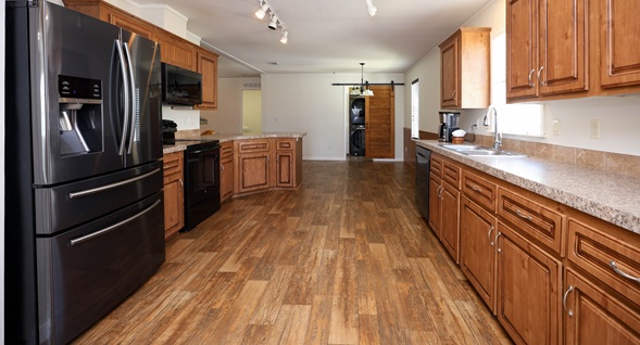 Gorgeous open concept kitchen with ample cabinetry, vinyl plank flooring and track lighting.