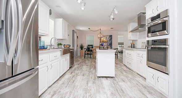 Spacious gourmet kitchen at Driftwood & Dreams in Rexmere Village, featuring white cabinetry, center island, stainless steel appliances and beachwood-