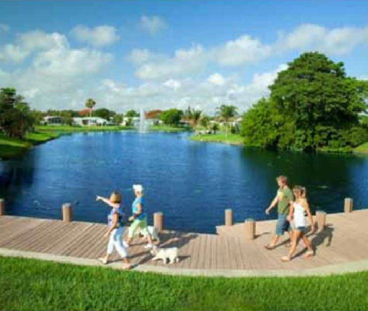 Rexmere Lake with two couples walking dogs along a wooden boardwalk